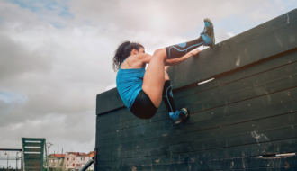 woman climbing wall showing how to overcome obstacles